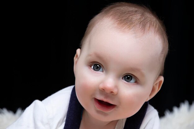 Lindo menino sorri e olha para a câmera. Bebê de quatro meses. Uma criança engraçada.