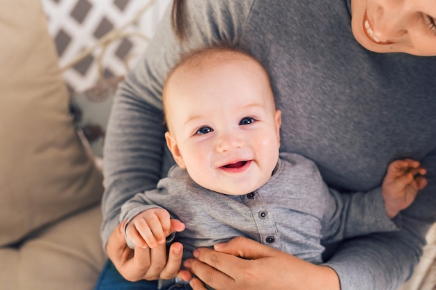 Lindo menino sorridente fofo com a mãe