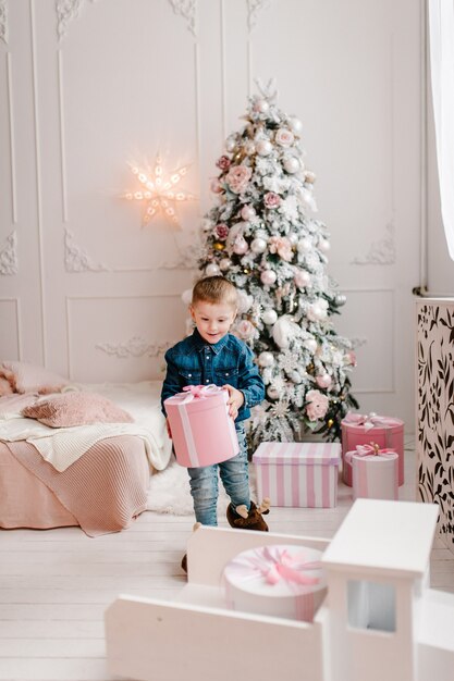 Lindo niño abriendo regalos de Navidad