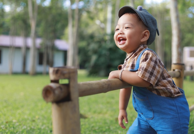 Lindo niño asiático jugando en el jardín