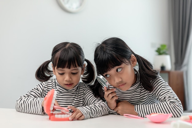 Lindo niño asiático jugando con el juego de juguetes médico dentista niño muestra cómo limpiar y cuidar los dientes Odontología y medicina