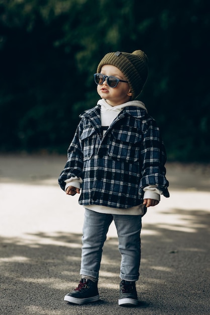 Lindo niño caminando en un parque de otoño