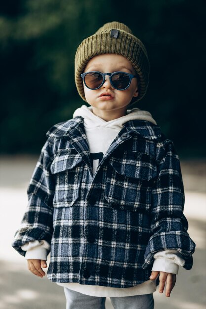 Lindo niño caminando en un parque de otoño