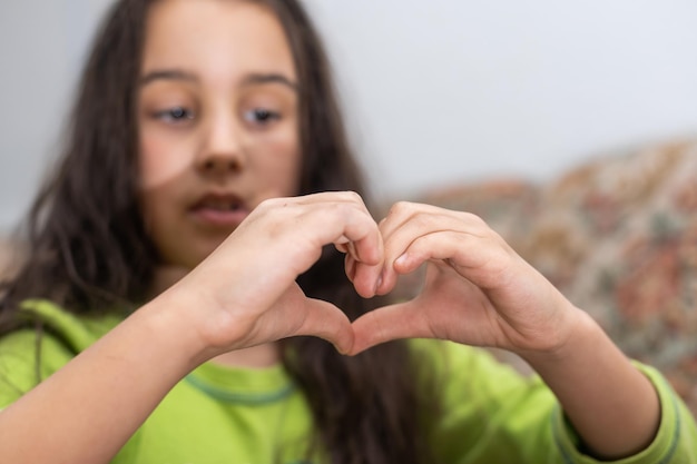 Un lindo niño caucásico sostiene una palma en forma de corazón.