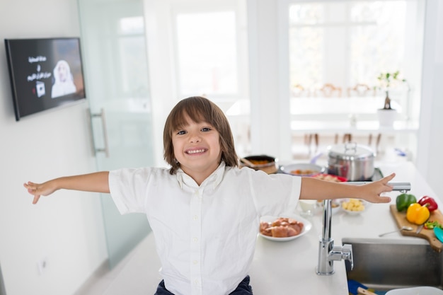 Lindo niño en la cocina moderna