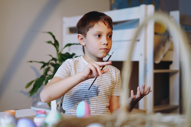 Lindo niño coloreando huevos para pascua