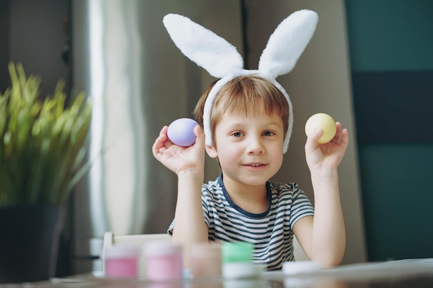 Lindo niño coloreando huevos para pascua