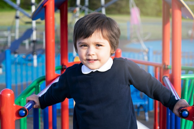 Lindo niño divirtiéndose en el patio de recreo