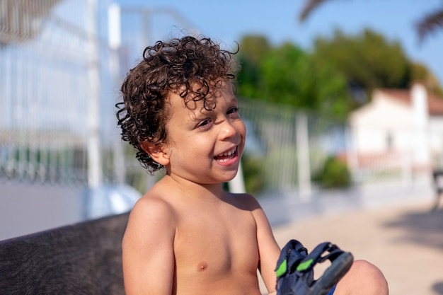 Lindo niño feliz recién salido de la piscina