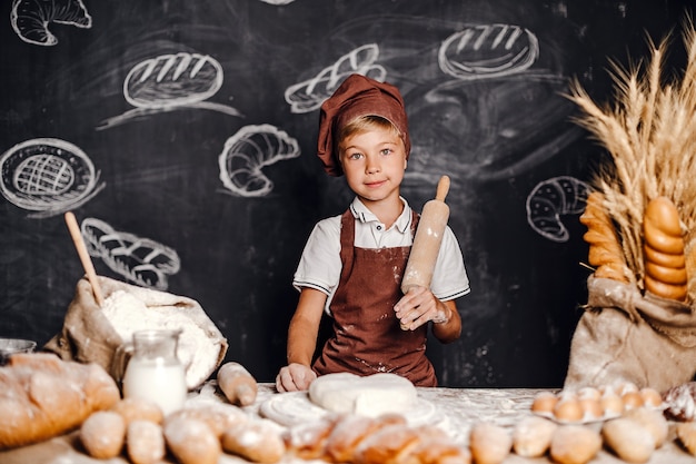 Lindo niño con gorro de cocinero cocinando