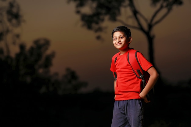 Lindo niño indio con bolsa de saco en la calle