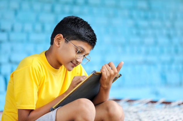 Lindo niño indio estudiando en casa