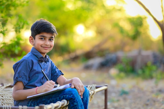 Lindo niño indio haciendo su tarea en casa