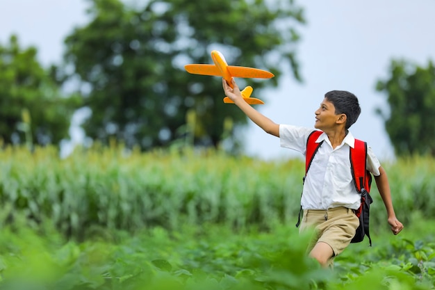 Lindo niño indio jugando con un avión de juguete