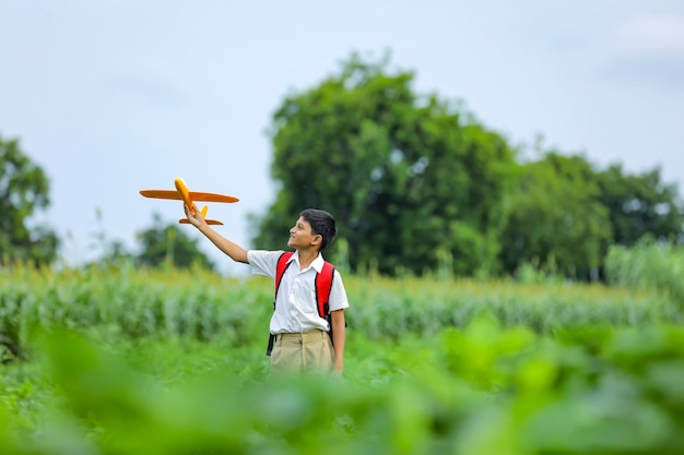 Lindo niño indio jugando con un avión de juguete