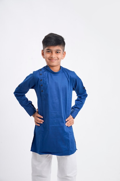 Lindo niño indio en ropa étnica y mostrando expresión en blanco