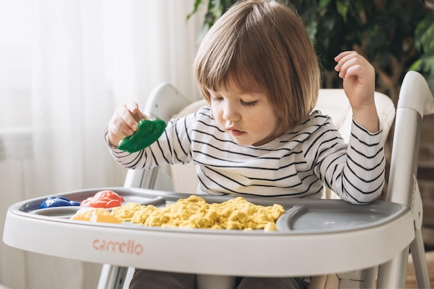 Lindo niño jugando con arena cinética Desarrollo de habilidades motoras finas Educación sensorial temprana Actividades Juegos sensoriales Montessori en casa