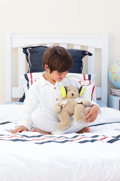 Lindo niño jugando con un oso de peluche