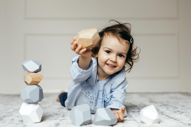 Lindo niño jugando con piedras de madera o rocas llamado Tumi Ishi de Japón