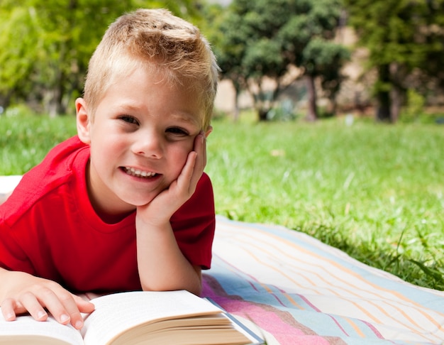 Lindo niño leyendo en un picnic