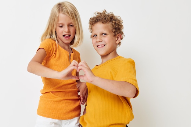 Lindo niño y niña en camisetas amarillas estudio de entretenimiento infantil