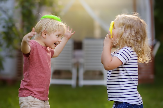 Lindo niño y niña jugando en el juego lanzando anillos en verano al aire libre