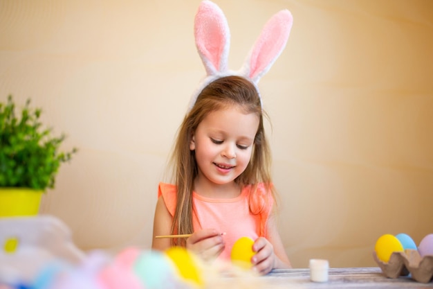 Lindo niño en orejas de conejo se prepara para pascua huevos de pascua pintados feliz concepto de pascua