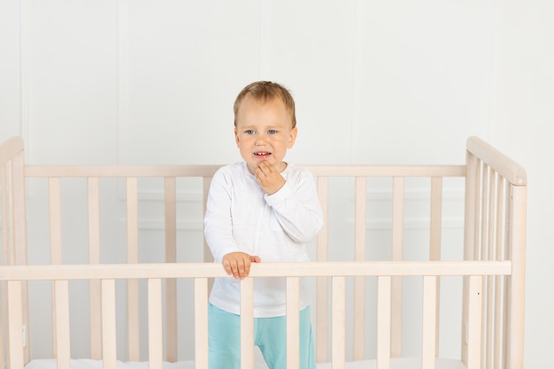 Lindo niño parado en la cama