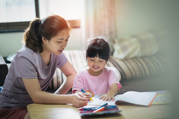 Lindo niño pequeño pintando con pinturas de colores Niña asiática y su madre usando crayón dibujo colorBaby artista actividad estilo de vida concepto