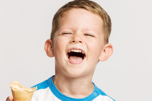 Lindo niño pequeño, rubio, untado con helado