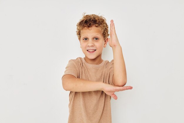 Lindo niño pequeño sobre un fondo claro posando sonrisa