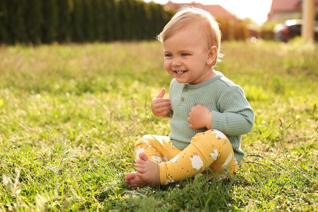 Lindo niño pequeño sobre hierba verde al aire libre