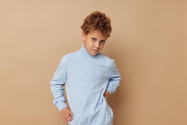 Lindo niño pequeño en un suéter azul posando diversión infancia inalterada