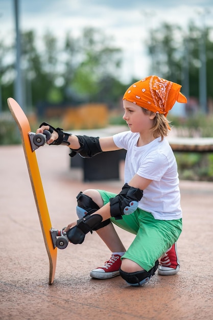 Lindo niño preadolescente preparándose para andar en patineta