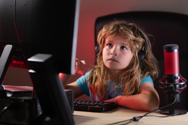 Lindo niño preescolar viendo una lección de video por computadora portátil