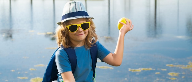 Lindo niño rubio con binoculares con sombrero de explorador y mochila en la naturaleza Niño explorador senderismo y aventura