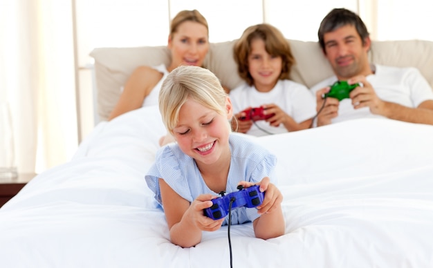 Lindo niño rubio jugando videojuegos con su familia