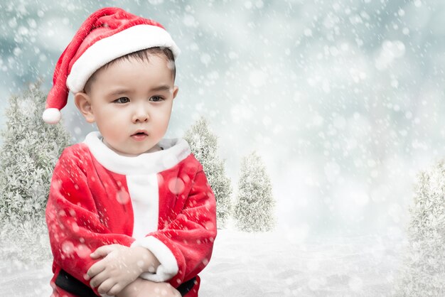 Lindo niño santa con nieve que cae