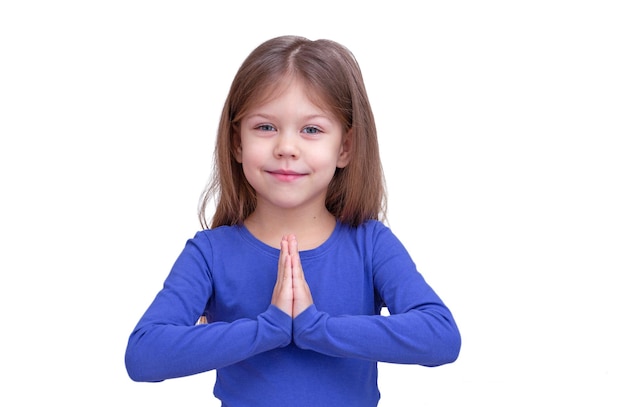 Lindo niño sonriente niño sosteniendo oraciones manos aisladas sobre fondo blanco mirando a la cámara cintura para arriba niña caucásica de 5 años en azul