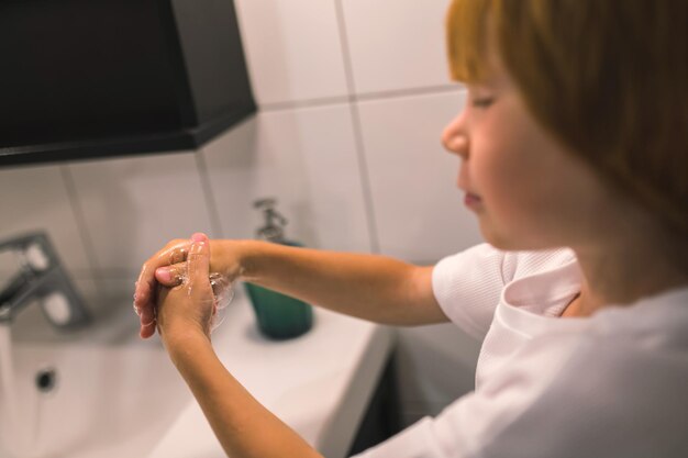 Lindo niño y su papá lavándose las manos en el baño