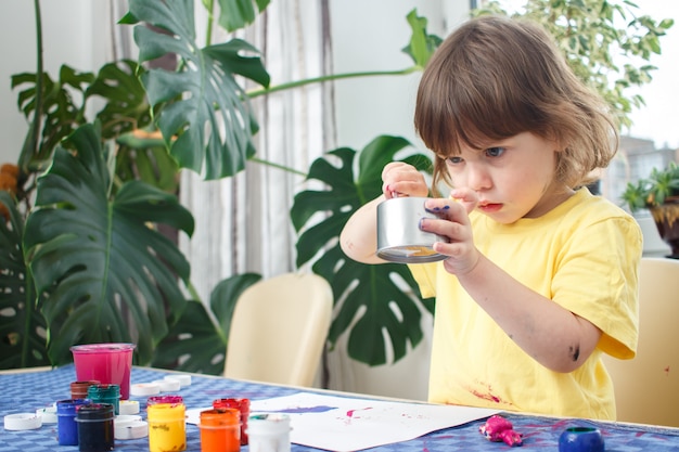 Un lindo niño de tres años se dedica a la creatividad.