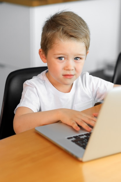 Lindo niño usando una computadora portátil