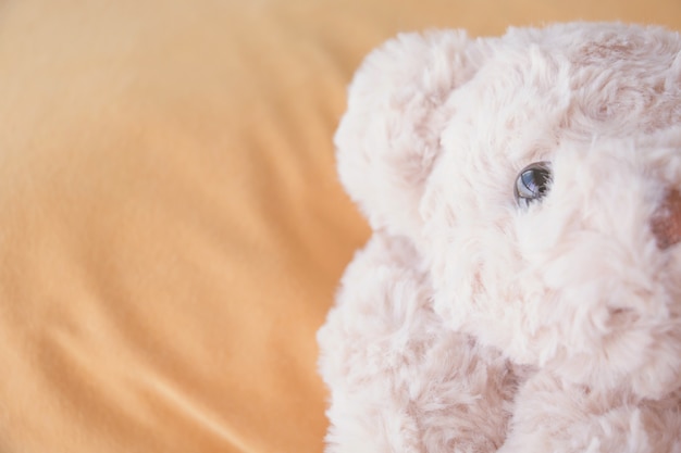 Lindo osito de peluche acostado en la cama.