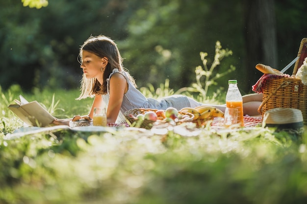 Un lindo pasar un día de primavera en la naturaleza y leer un libro en un picnic.