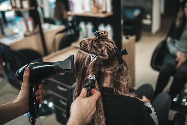 Lindo penteado de mulher depois de tingir o cabelo e fazer destaques em salão de cabeleireiro.