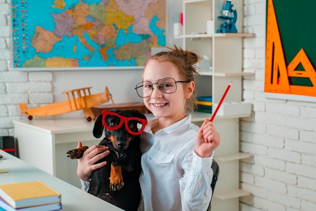 Lindo perrito juguetón o mascota con gafas mirando hacia arriba como un alumno cachorro divertido con gafas feliz sonriendo