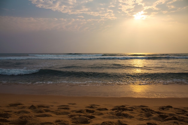 Lindo pôr do sol rosa junto ao oceano revolto