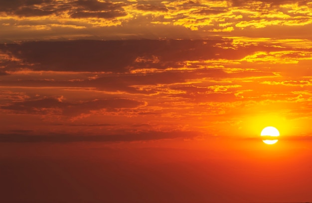 Foto lindo pôr do sol vermelho e sol forte no horizonte