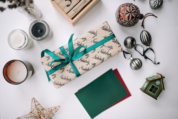 Lindo presente de Natal em uma mesa branca com enfeites e um cartão em branco