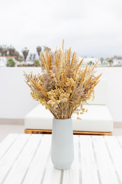 Lindo ramo de flores secas (cola de conejo) en la terraza de una casa